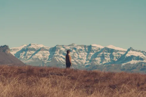 Scenic image of Juliette Gyure standing in a field with snowy mountains in the background